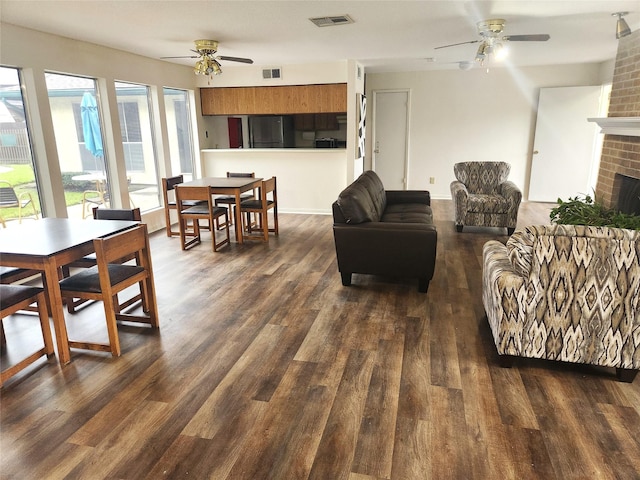 living room featuring a ceiling fan, dark wood-type flooring, and visible vents