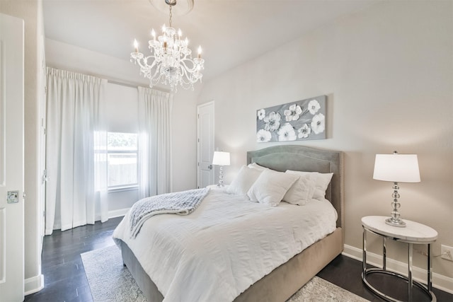 bedroom with dark wood-style floors, an inviting chandelier, and baseboards