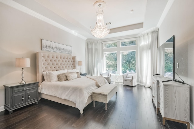 bedroom with ornamental molding, a tray ceiling, dark wood-type flooring, and a notable chandelier