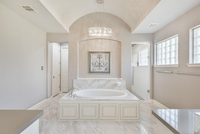 full bath featuring lofted ceiling, visible vents, a garden tub, and baseboards