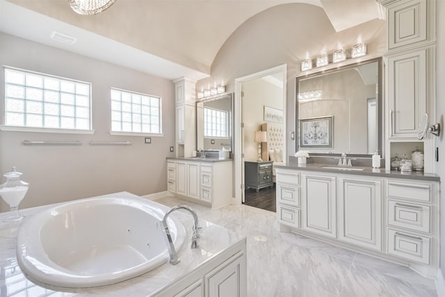 full bathroom with lofted ceiling, visible vents, two vanities, a sink, and a jetted tub