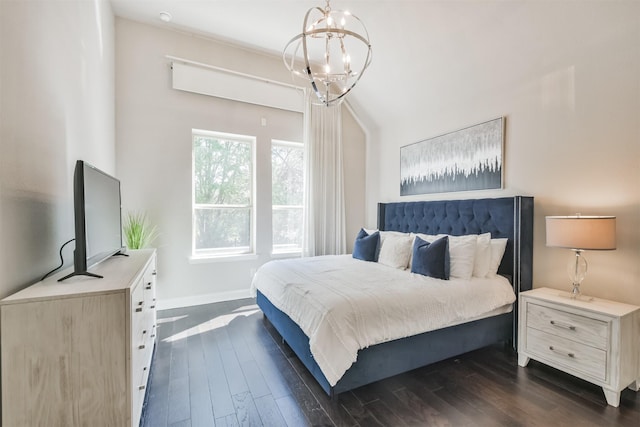 bedroom with a chandelier, dark wood-style flooring, and baseboards