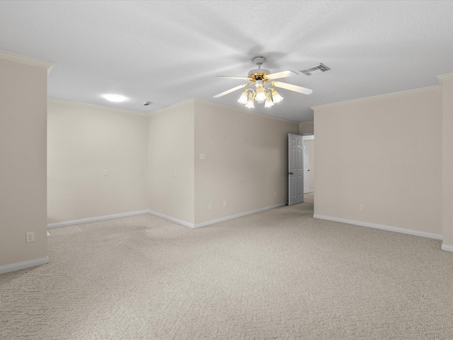 empty room featuring ceiling fan, ornamental molding, visible vents, and light colored carpet