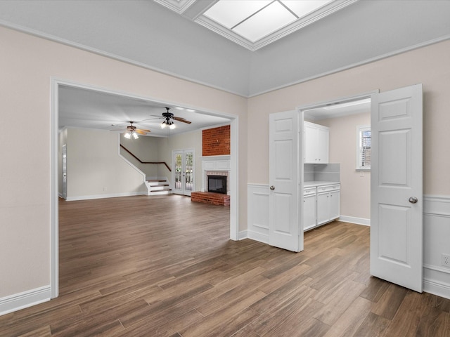 unfurnished living room featuring a fireplace, wood finished floors, and a healthy amount of sunlight