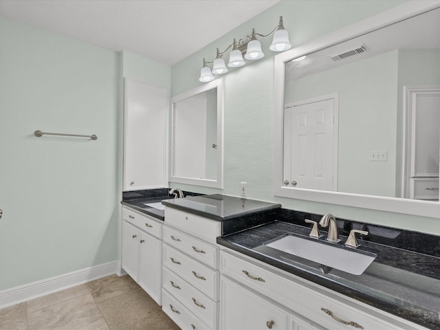 bathroom featuring visible vents, a sink, baseboards, and double vanity