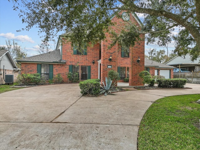 view of front of house with a garage, brick siding, driveway, and central air condition unit