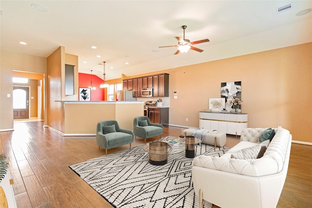 living room with a wealth of natural light, wood finished floors, visible vents, and recessed lighting