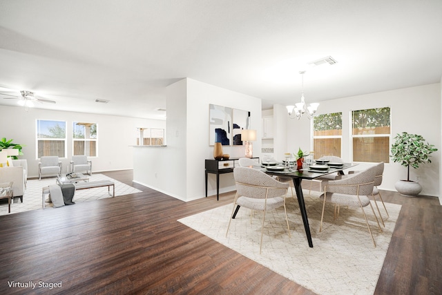 dining room featuring baseboards, visible vents, dark wood-type flooring, and ceiling fan with notable chandelier