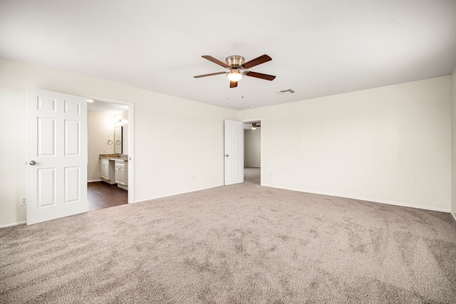 unfurnished room featuring a ceiling fan, visible vents, dark carpet, and baseboards