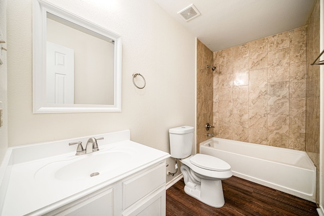 bathroom with toilet, wood finished floors, vanity, visible vents, and shower / bathing tub combination