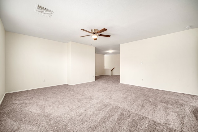 spare room featuring baseboards, carpet floors, visible vents, and a ceiling fan