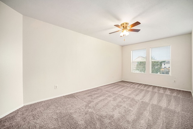 spare room featuring carpet floors, a textured ceiling, baseboards, and a ceiling fan