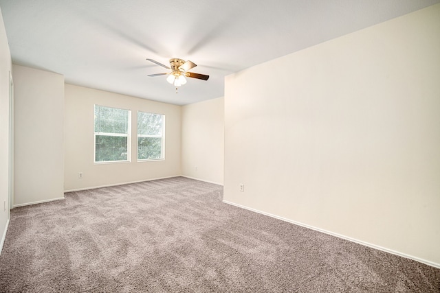 carpeted empty room featuring baseboards and a ceiling fan