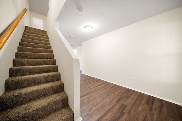 stairway with baseboards and wood finished floors