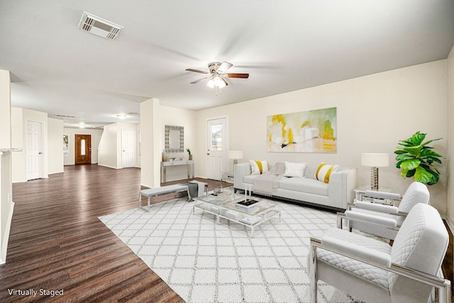 living room with baseboards, ceiling fan, visible vents, and wood finished floors