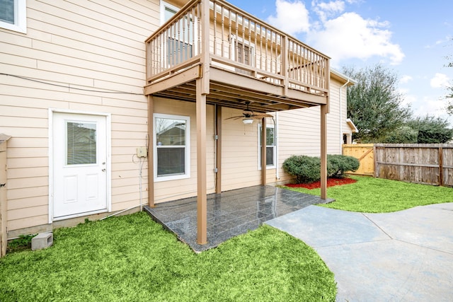 rear view of house with a ceiling fan, a balcony, fence, a yard, and a patio area