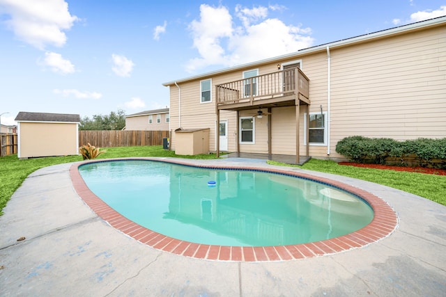 view of swimming pool with a fenced in pool, a lawn, fence, a shed, and an outdoor structure