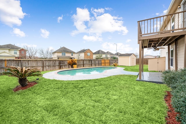 view of swimming pool featuring a fenced in pool, a fenced backyard, a residential view, a storage unit, and an outdoor structure