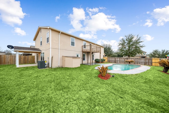 rear view of house with a yard, a fenced backyard, cooling unit, and a fenced in pool