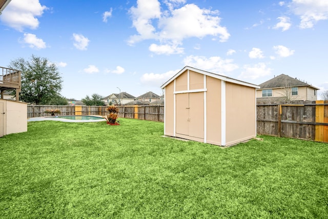 view of yard with a storage unit, an outdoor structure, a fenced backyard, and a fenced in pool