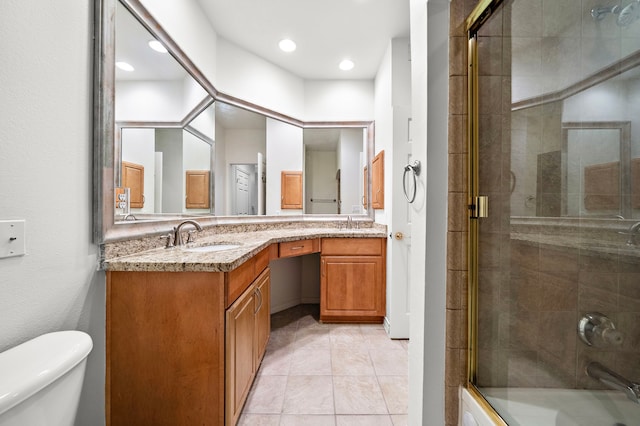 bathroom featuring tile patterned floors, a sink, toilet, and double vanity