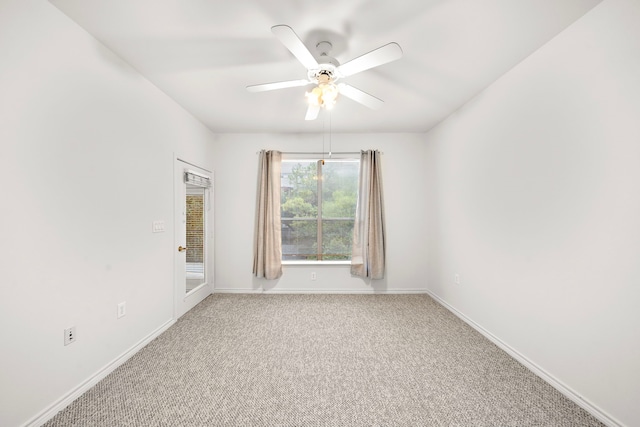 carpeted empty room featuring baseboards and a ceiling fan