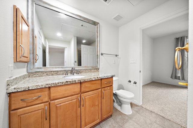 bathroom with toilet, vanity, and visible vents