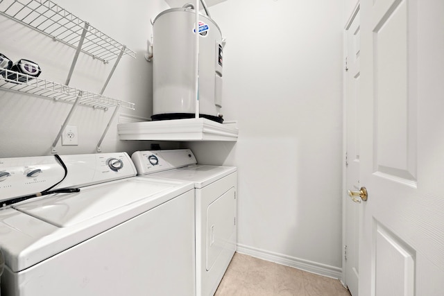 washroom featuring laundry area, washer and clothes dryer, baseboards, and light tile patterned floors