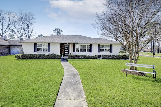 ranch-style house featuring a shingled roof, brick siding, and a front lawn