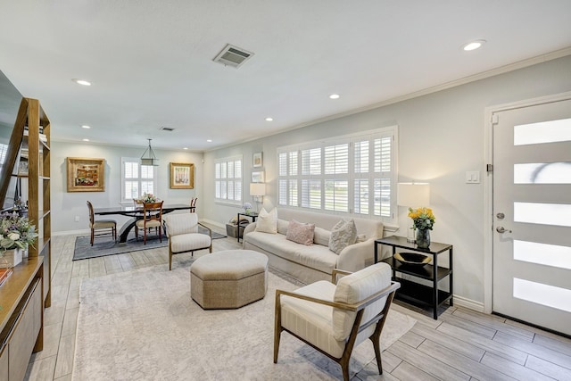 living area featuring baseboards, visible vents, and wood finish floors