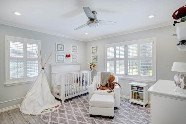 bedroom featuring a nursery area, ornamental molding, and multiple windows