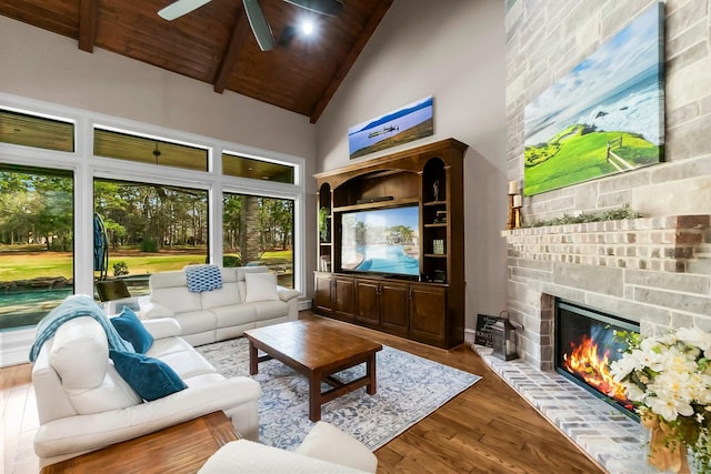 living area featuring a fireplace, ceiling fan, wood finished floors, high vaulted ceiling, and wooden ceiling