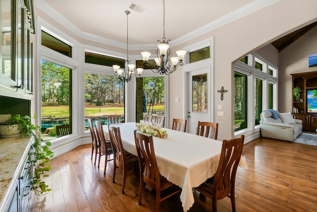 dining space with light wood finished floors, visible vents, and crown molding