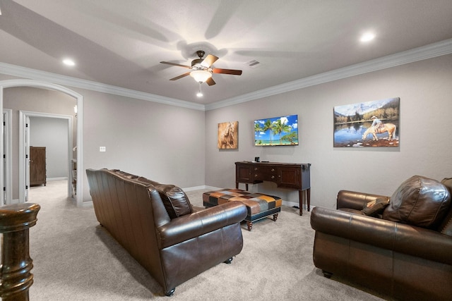 living room featuring arched walkways, ornamental molding, a ceiling fan, and light colored carpet