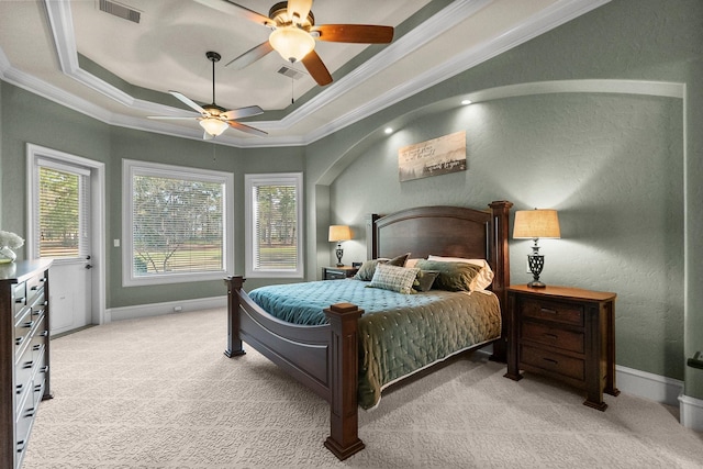 bedroom featuring light carpet, a tray ceiling, visible vents, and crown molding