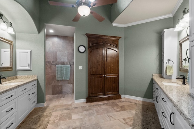 bathroom with crown molding, two vanities, a sink, and baseboards