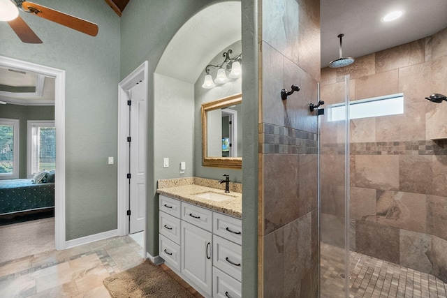 ensuite bathroom featuring a stall shower, baseboards, ceiling fan, ensuite bathroom, and vanity