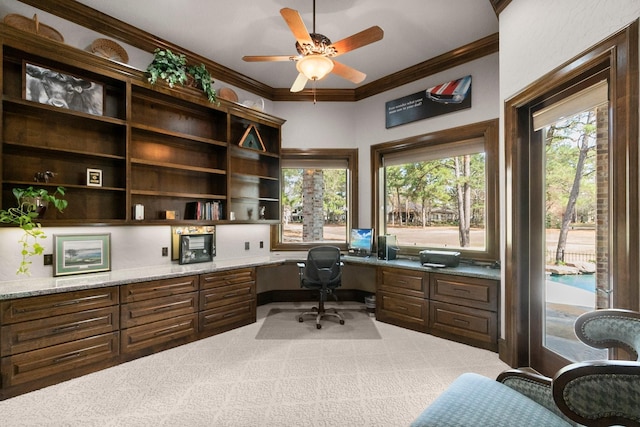 office space featuring built in desk, carpet flooring, a wealth of natural light, and crown molding