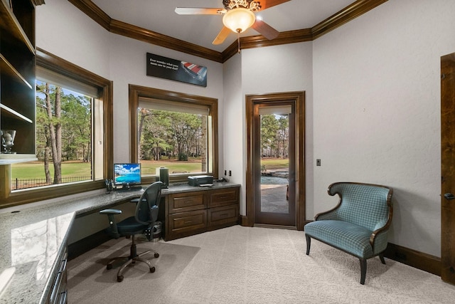 home office featuring light carpet, ornamental molding, built in study area, and a wealth of natural light