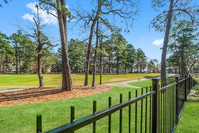 view of property's community with a yard and fence