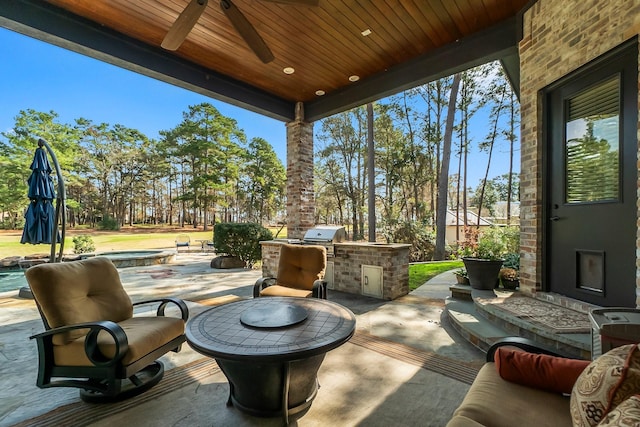 view of patio with area for grilling, a grill, and a ceiling fan