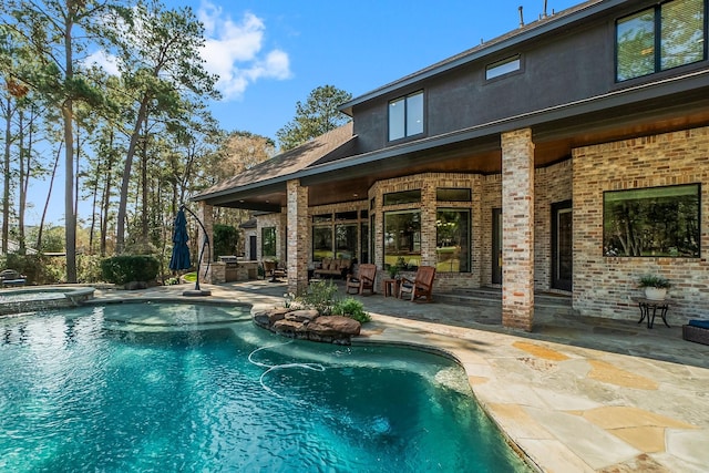 view of pool with a patio and a pool with connected hot tub