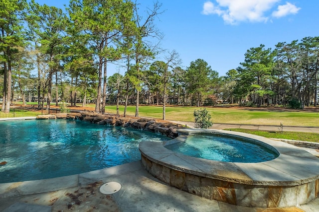 view of pool featuring a pool with connected hot tub, fence, and a lawn