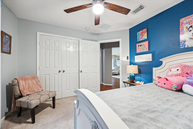 bedroom with a ceiling fan, light colored carpet, a closet, and visible vents