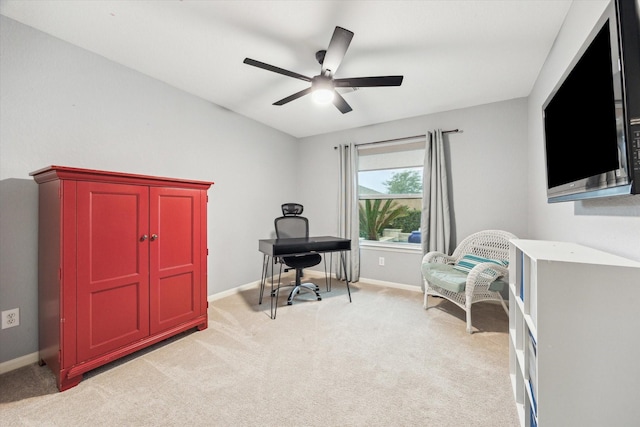 office featuring a ceiling fan, light colored carpet, and baseboards