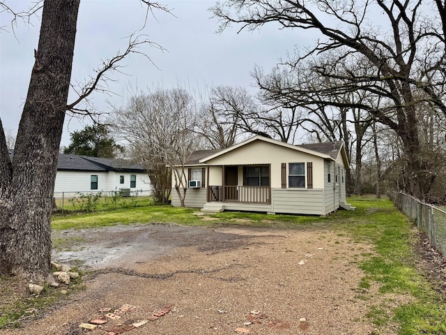 view of front facade with driveway, fence, and cooling unit