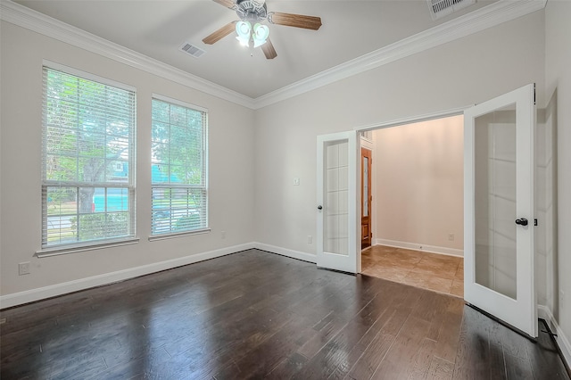 empty room with baseboards, visible vents, dark wood finished floors, crown molding, and french doors