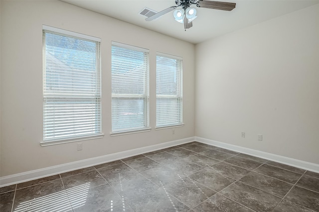 spare room featuring baseboards, visible vents, and a ceiling fan