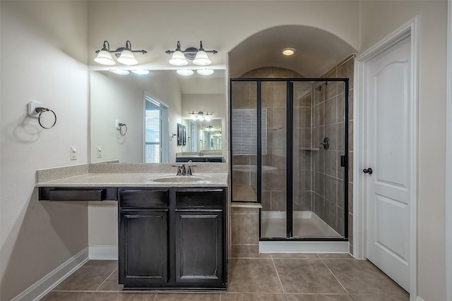 full bathroom featuring a shower stall, vanity, baseboards, and tile patterned floors