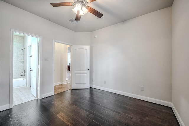 spare room featuring dark wood-style flooring, visible vents, ceiling fan, and baseboards